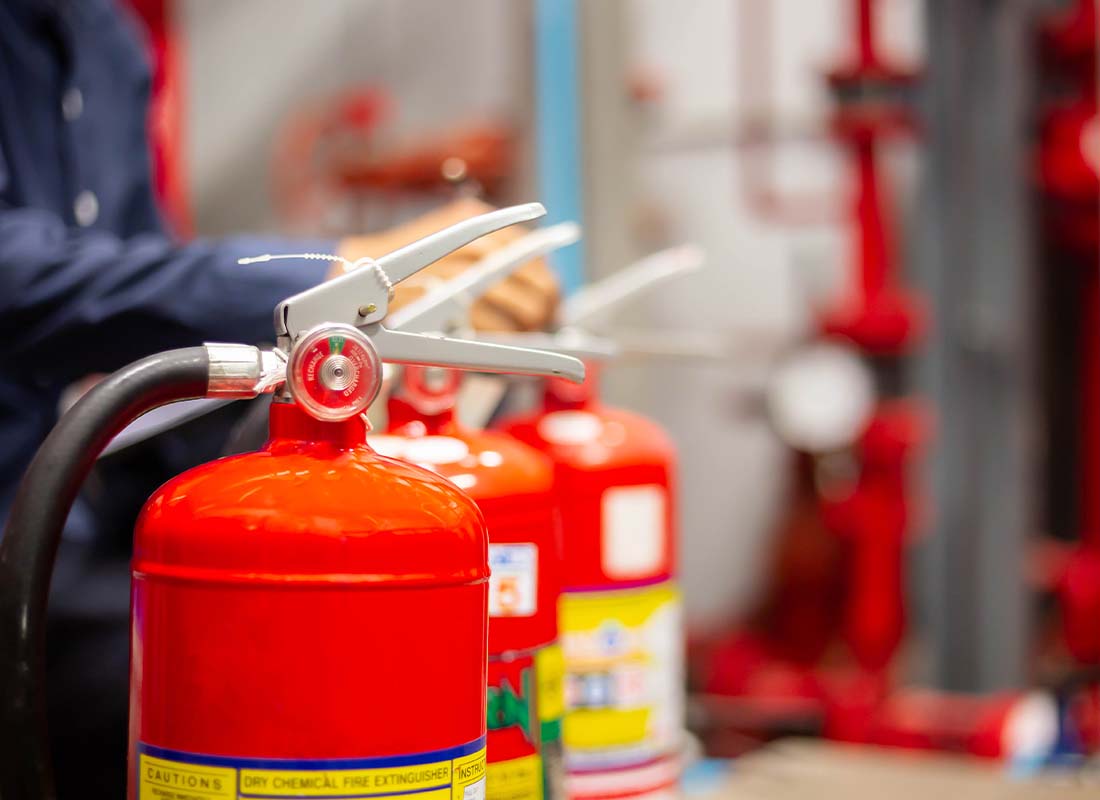 Fire Protection Contractor Insurance - Focus on Fire Extinguishers With an Engineer Checking Industrial Fire Control System to Ensure Readiness in the Event of a Fire