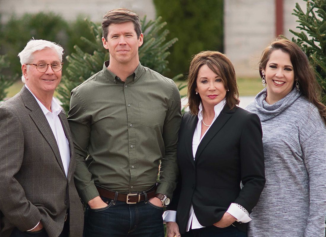 About Our Agency - Portrait of Grier Insurance Agency Team Members Standing Outside the Office Building in Front of Green Foliage