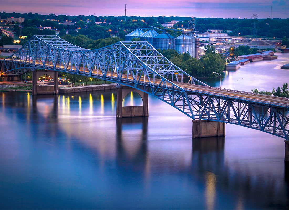 Florence, AL - View of a Bridge Across the River with Commercial and Industrial Buildings in Downtown Florence Alabama in the Background